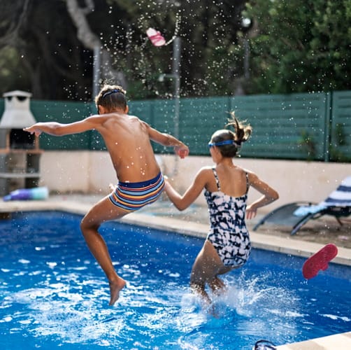 Kids jumping in the pool.