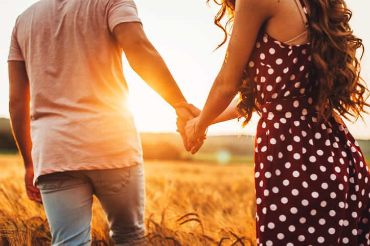 couple holding hands in the sunset