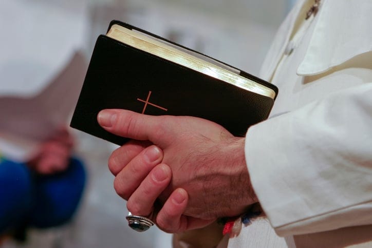 priest holding bible