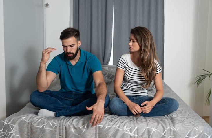 young couple arguing in bed