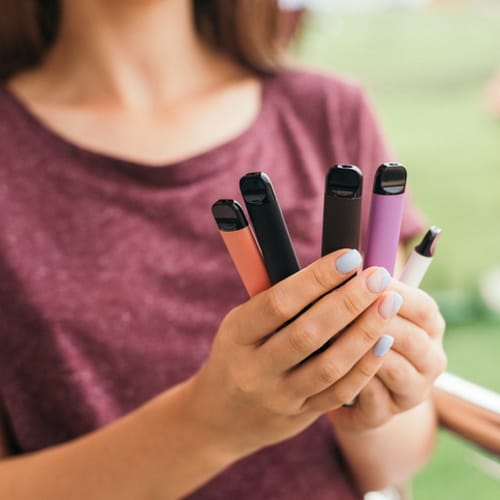 woman with stack of vapes