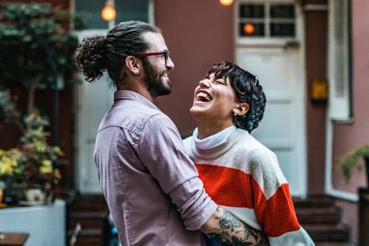 couple laughing and embracing in street