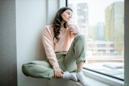 sad woman sitting on a window