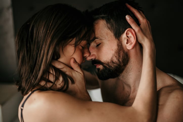 couple embracing naked in bed