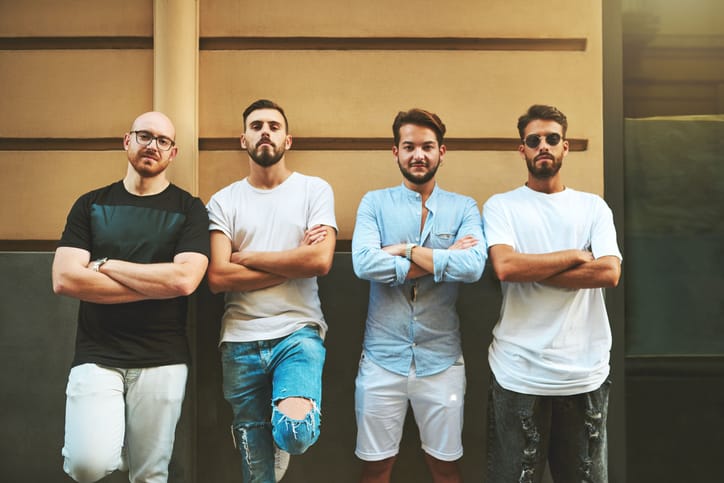 four men standing arms crossed