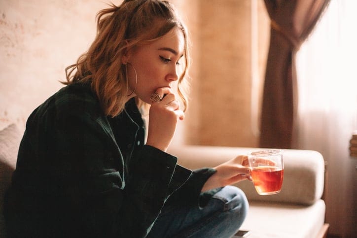 woman looking sad with cup of tea