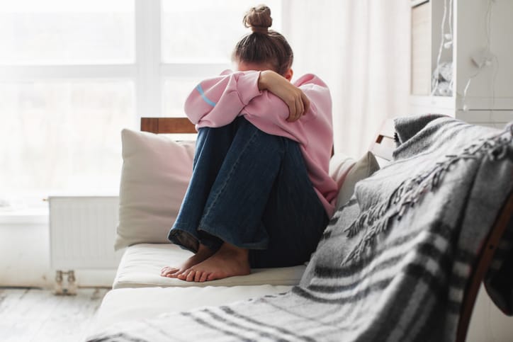 sad woman sitting on couch