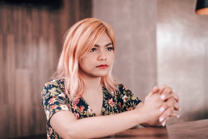 woman with pink hair praying
