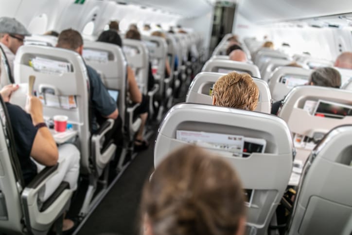 Interior of commercial airplane with passengers in their seats.