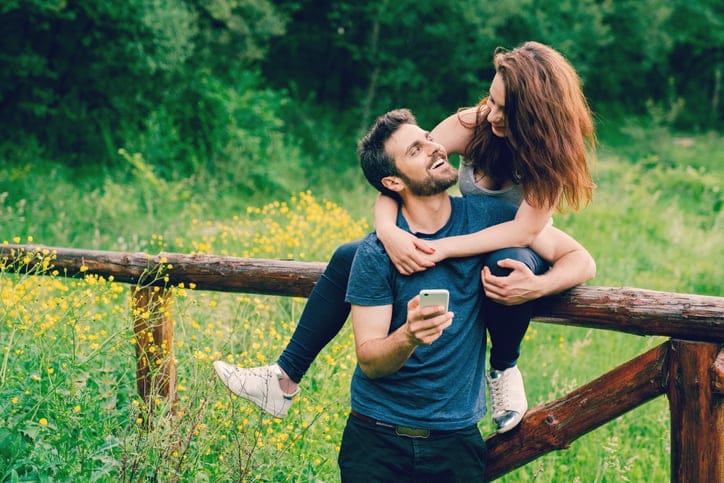 happy couple embracing in field