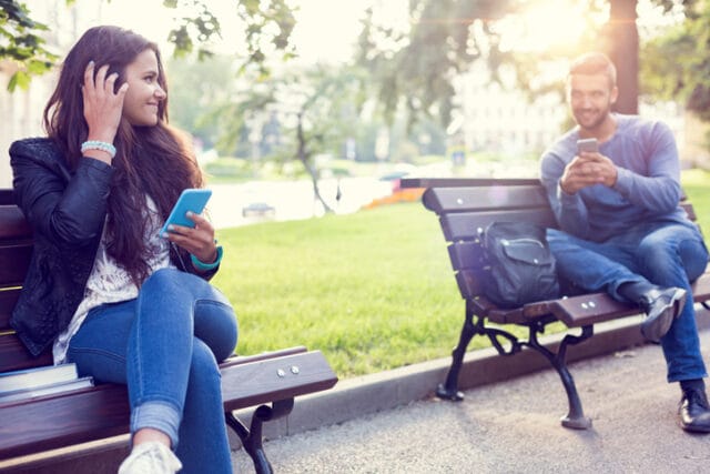 couple flirting on park benches