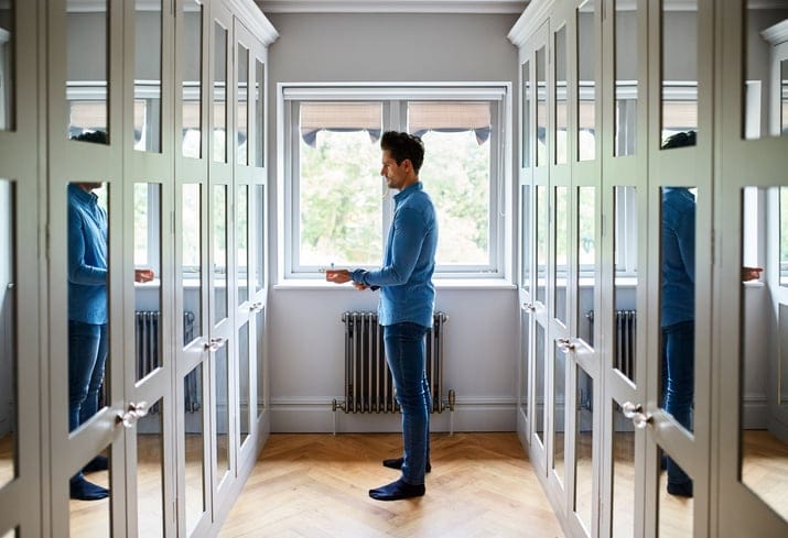 man getting dressed in mirror