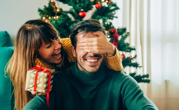 Romantic young couple exchanging Christmas gifts.