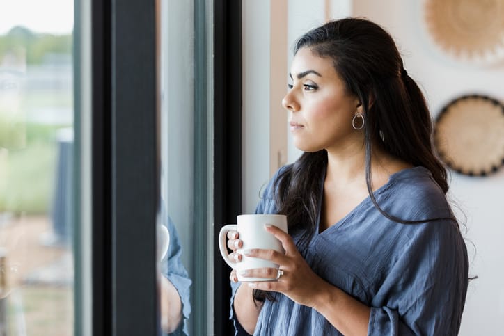 pensive woman looking out window
