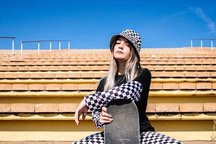 confident young woman with skateboard
