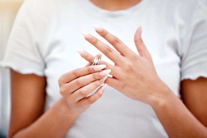 Woman removing her engagement ring.