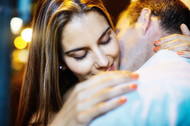 man passionately kissing woman's neck