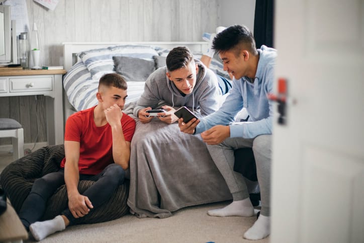 boys texting in bedroom