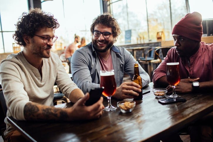 guy friends drinking at bar