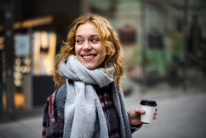 happy woman with coffee walking