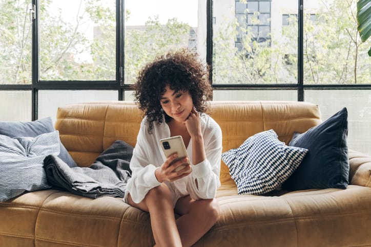 woman texting on the couch
