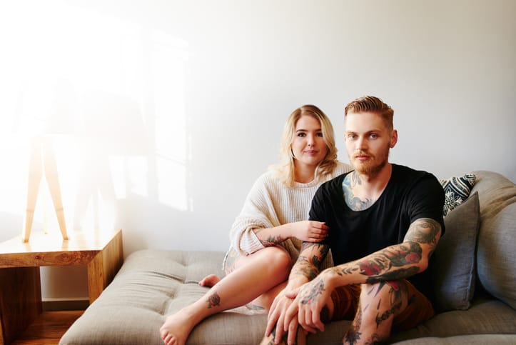 serious couple sitting on couch