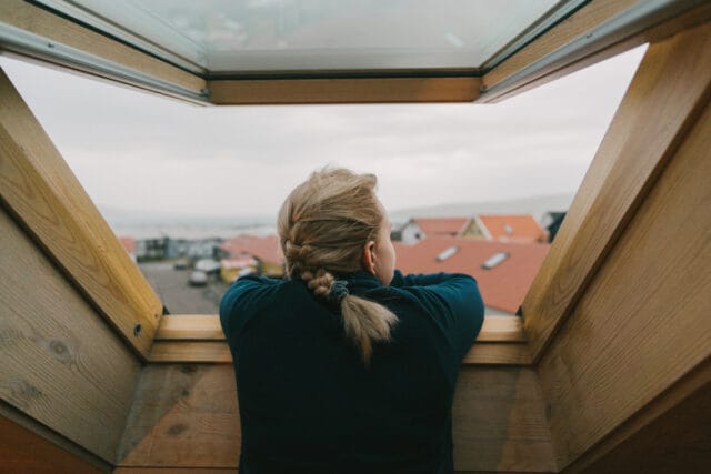 Woman looking out her window.