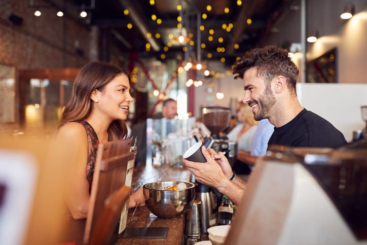 male barista making customer's coffee