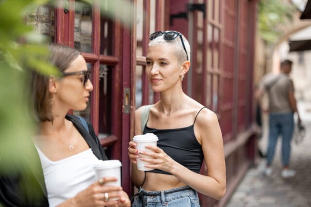 stylish friends hanging on city street