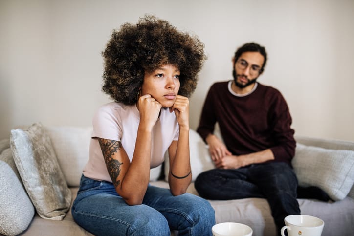 upset woman on couch with boyfriend
