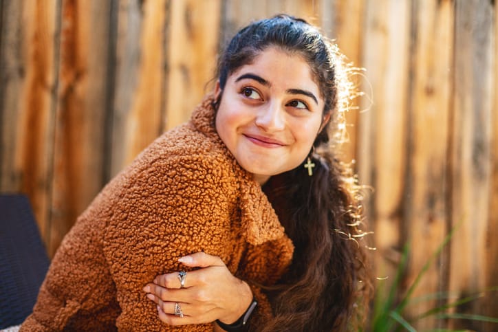 smiling woman looking over shoulder
