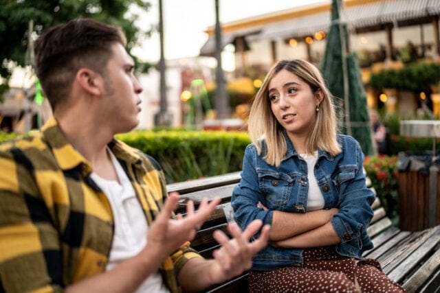 couple arguing on park bench