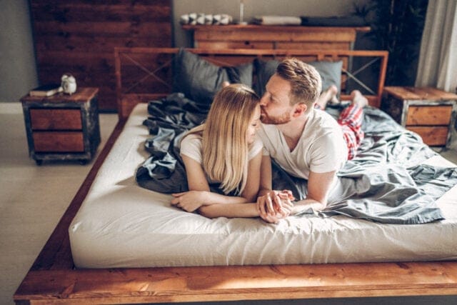 couple kissing tenderly in bed