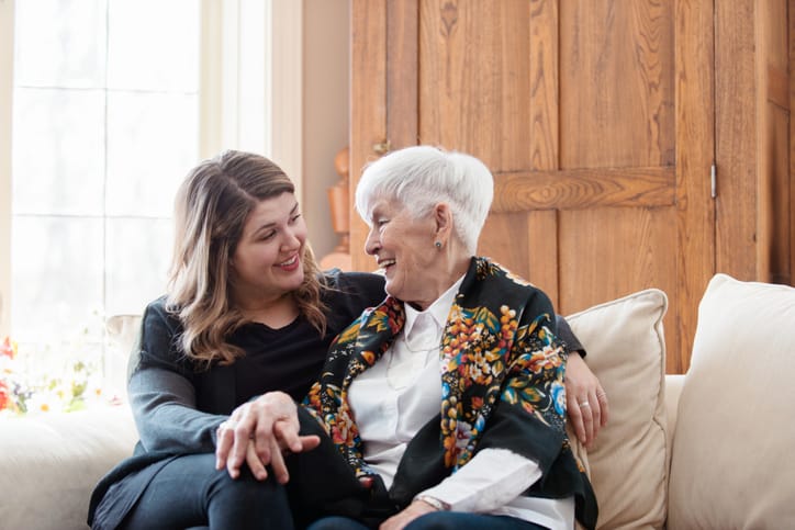 woman sitting with grandmother on couch