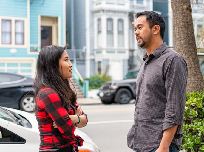man and woman talking on city street