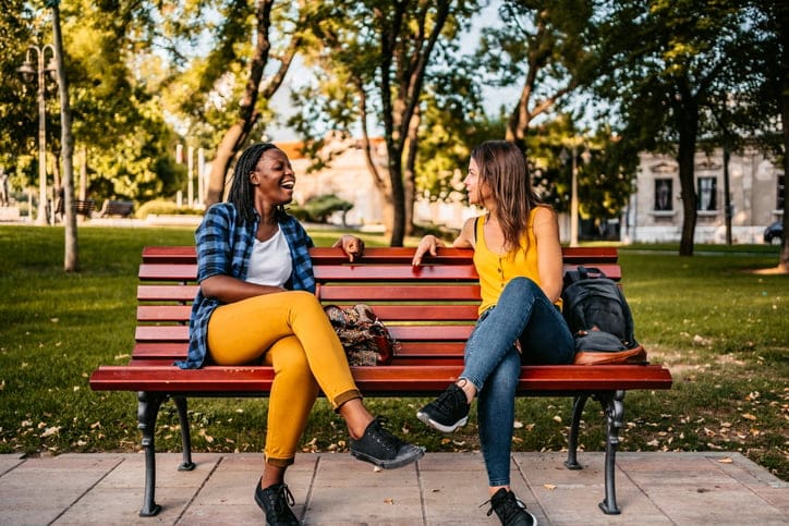 friends sitting on park bench