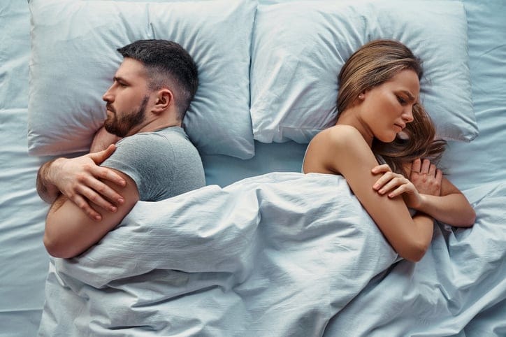 angry couple back to back in bed