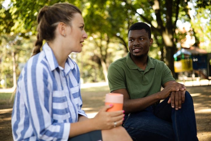 friends chatting over coffee at a park