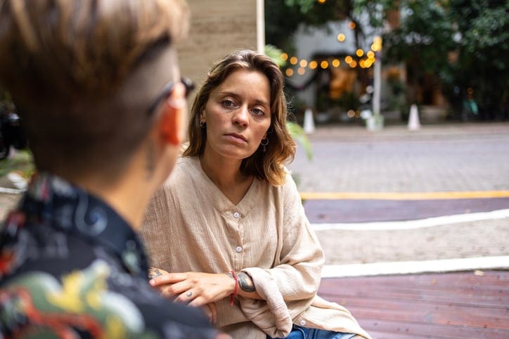 woman taling to partner on bench