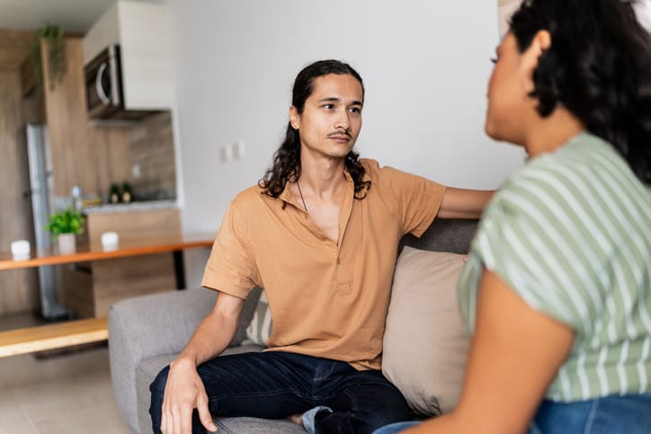 man chatting with girlfriend on couch