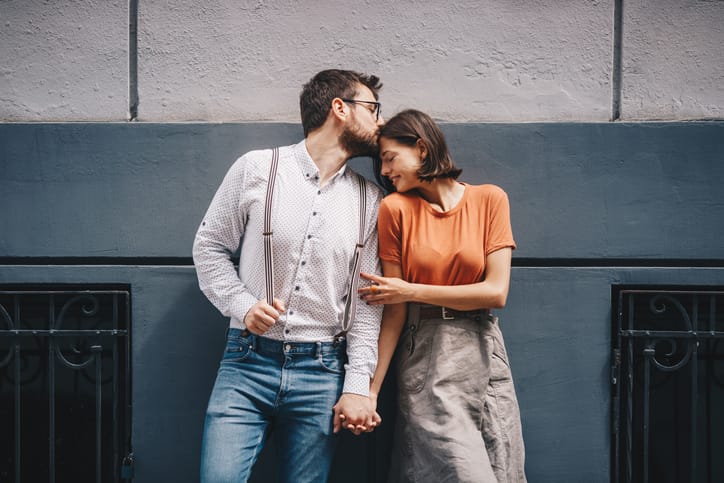 boyfriend kissing girlfriend's forehead outdoors