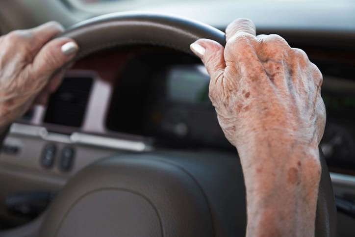 senior woman's hands on steering wheel