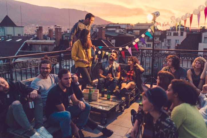 Friends having rooftop party at sunset.