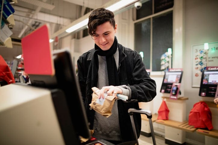 Man using self-checkout at store.