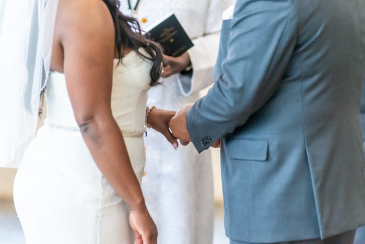 Couple exchanging rings at altar.