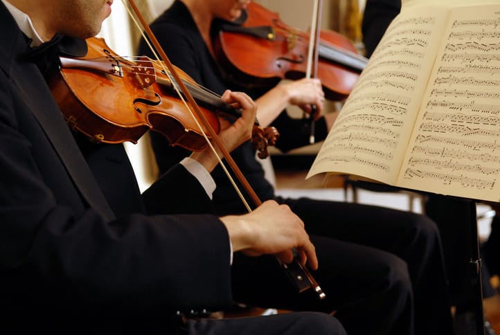 Orchestra members playing violins.