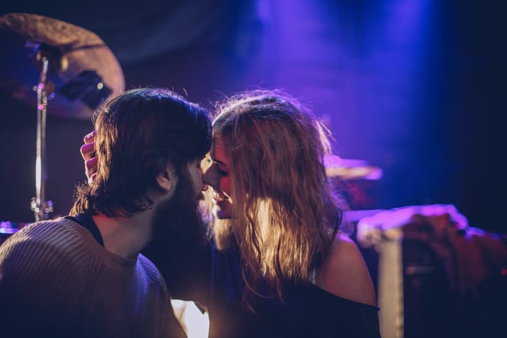 couple kissing at dark concert