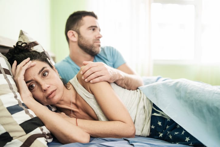 upset woman in bed with partner