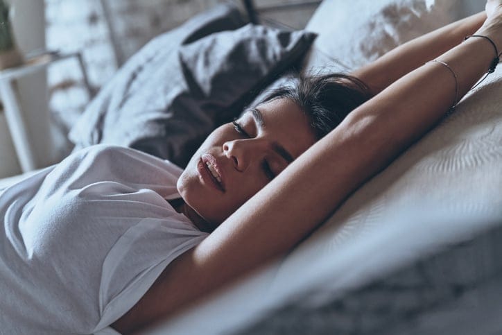 Woman laying in bed alome.