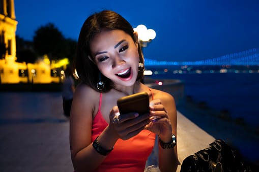 Woman on mobile phone on luxury hotel terrace.